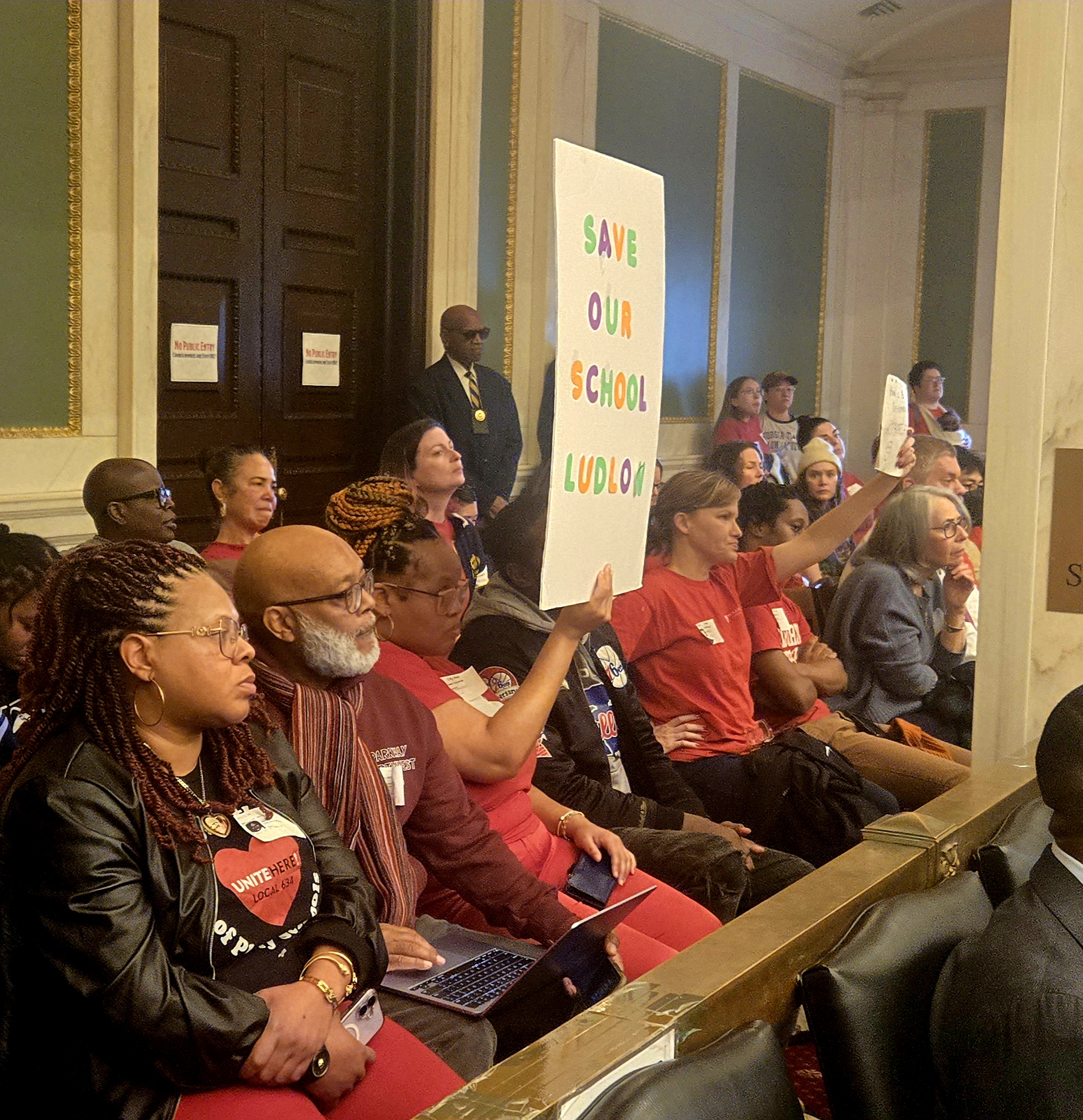 PFT members hold up signs urging City Council to force the District to rethink its 10-year Facilities Master Plan